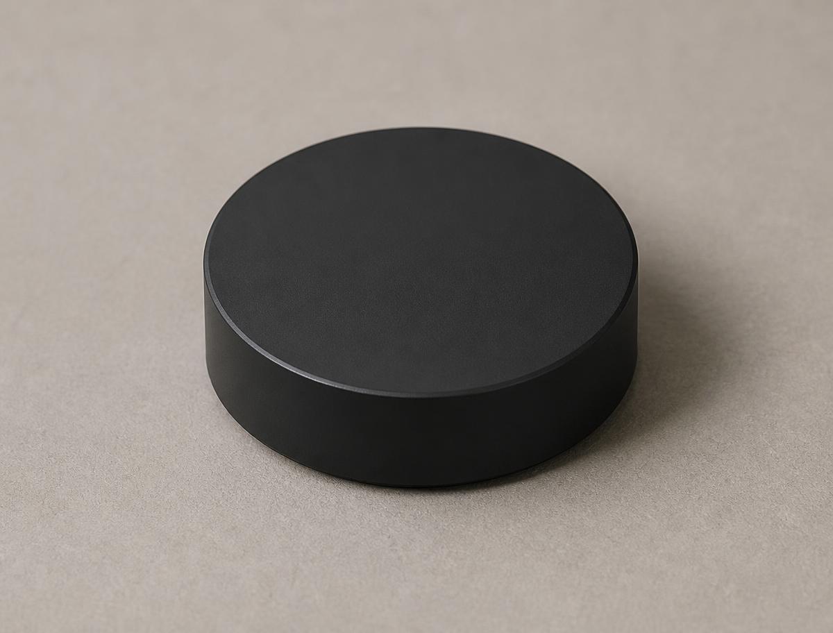 The Vokter sensor: a small matte black disc, 48 mm across